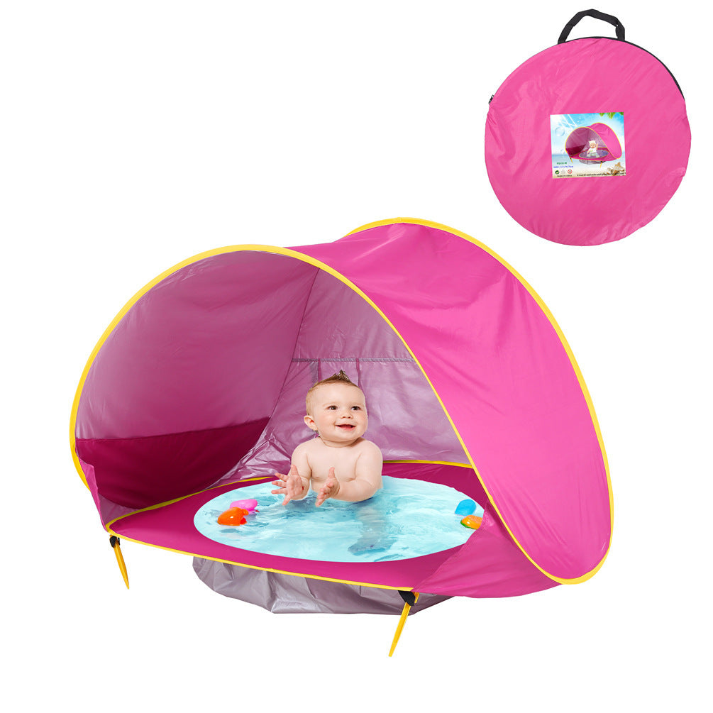Ein BeachPool Zelt in Blau mit gelben Akzenten, aufgestellt und in Benutzung mit einem lächelnden Baby, das im integrierten Wasserpool sitzt. Das Zelt ist mit Wasserspielzeug ausgestattet. Ein kleines Bild in der oberen rechten Ecke zeigt das Zelt in seiner lila Tragetasche.